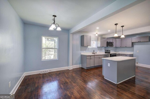 kitchen featuring hanging light fixtures, stainless steel appliances, dark wood-type flooring, and gray cabinetry