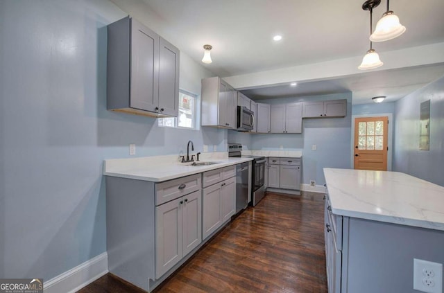 kitchen featuring gray cabinetry, sink, pendant lighting, appliances with stainless steel finishes, and dark hardwood / wood-style flooring