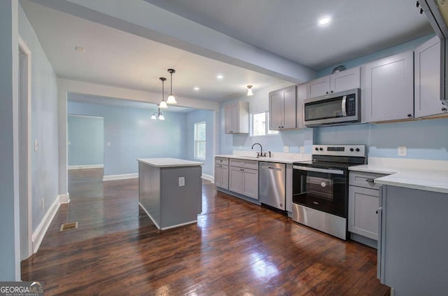 kitchen featuring stainless steel appliances, decorative light fixtures, dark hardwood / wood-style floors, and gray cabinets