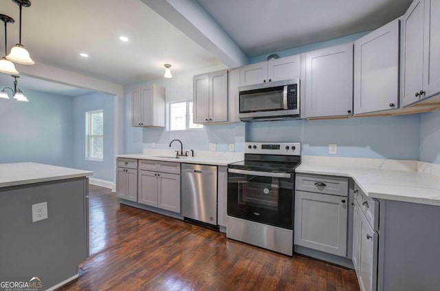 kitchen featuring gray cabinetry, sink, hanging light fixtures, stainless steel appliances, and dark wood-type flooring