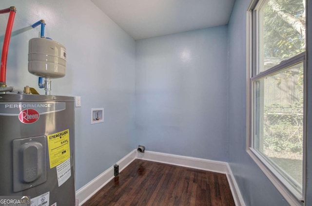 washroom with dark wood-type flooring, electric water heater, and hookup for a washing machine