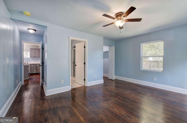 unfurnished bedroom with ensuite bathroom, dark hardwood / wood-style floors, and ceiling fan