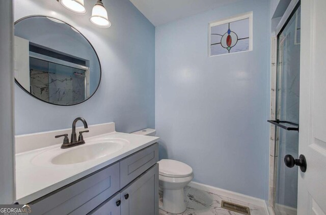 bathroom with toilet, walk in shower, and vanity