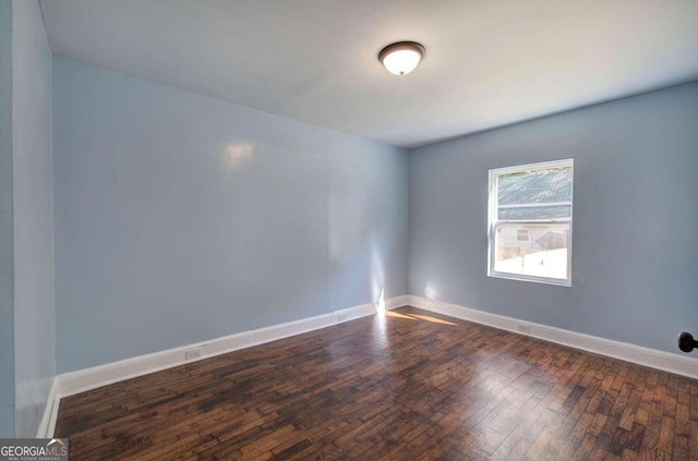 empty room with dark hardwood / wood-style flooring