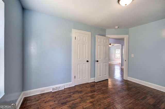 unfurnished room featuring dark wood-type flooring