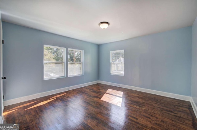 empty room with dark hardwood / wood-style flooring