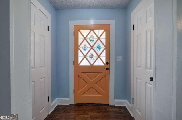 doorway to outside with a textured ceiling and dark hardwood / wood-style flooring