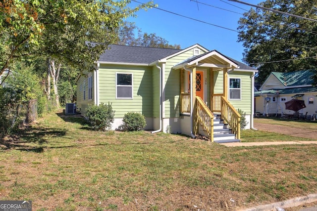 bungalow featuring central air condition unit and a front yard