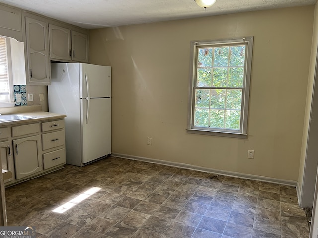 kitchen with a textured ceiling and white fridge