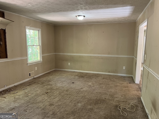 unfurnished room featuring a textured ceiling, carpet floors, and ornamental molding