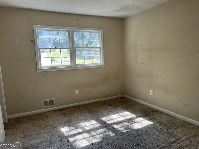 spare room with a textured ceiling and carpet