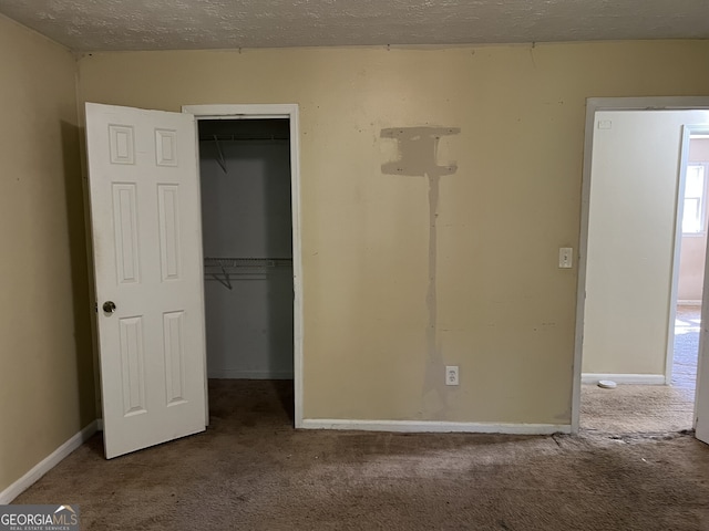 unfurnished bedroom featuring a closet, carpet floors, and a spacious closet