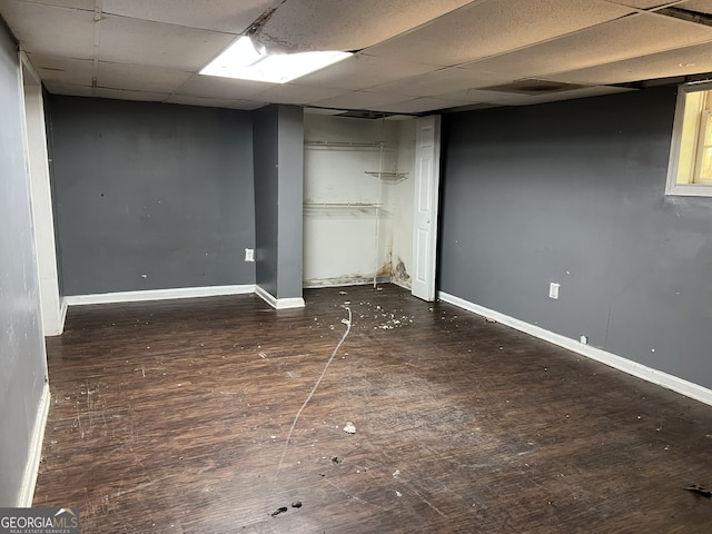 interior space featuring a drop ceiling and dark hardwood / wood-style flooring