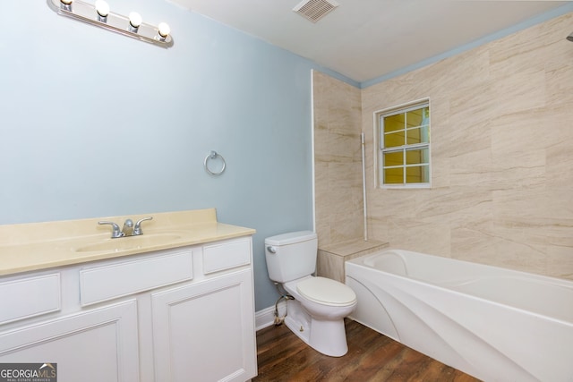 full bathroom with vanity, toilet, tiled shower / bath combo, and hardwood / wood-style floors