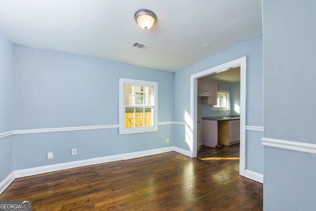 spare room with sink and dark hardwood / wood-style flooring