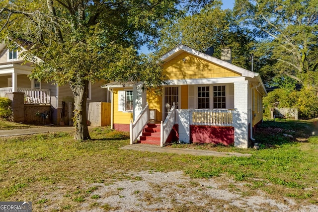 bungalow-style house featuring a porch and a front lawn