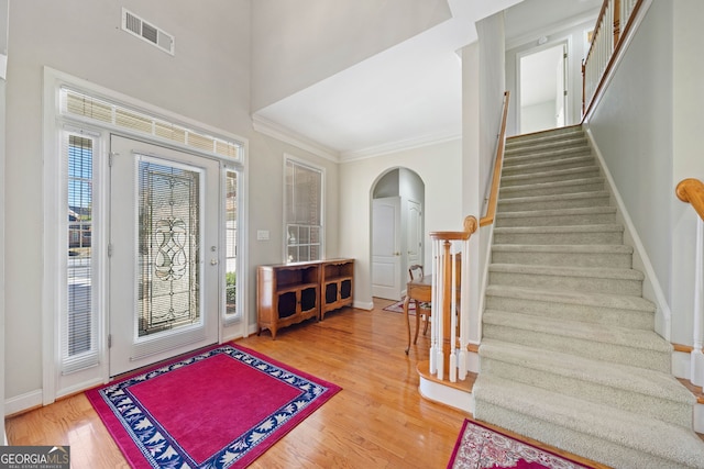 entrance foyer with crown molding and wood-type flooring