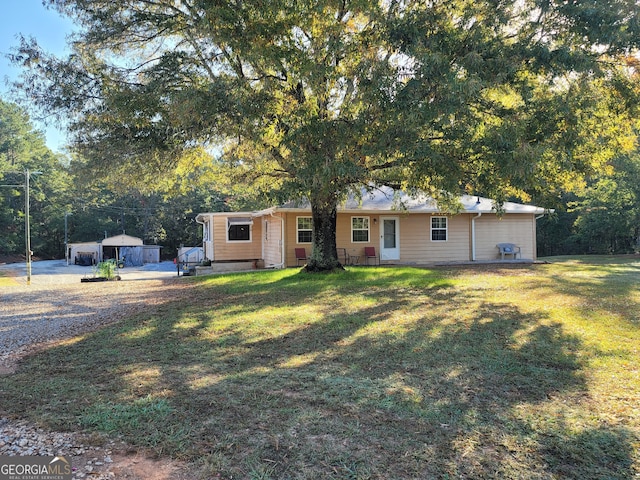 ranch-style home with an outbuilding, a front yard, and a garage