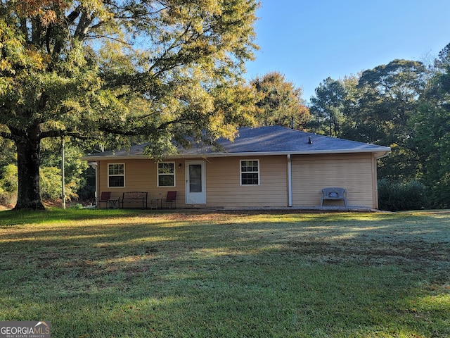 back of property featuring a lawn