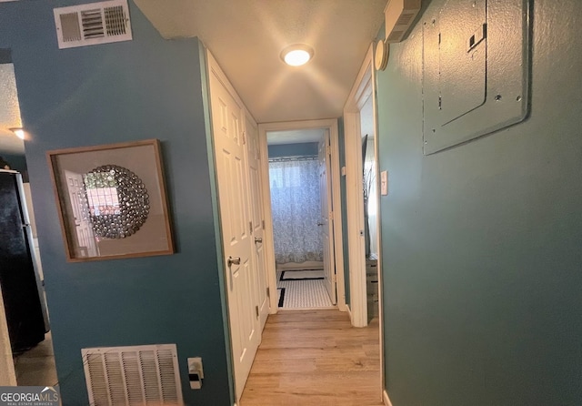 hallway featuring light hardwood / wood-style floors and electric panel