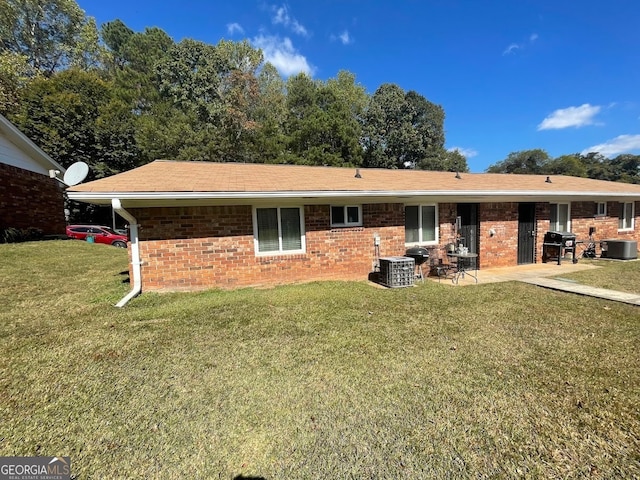 rear view of house featuring a yard, a patio area, and central AC unit