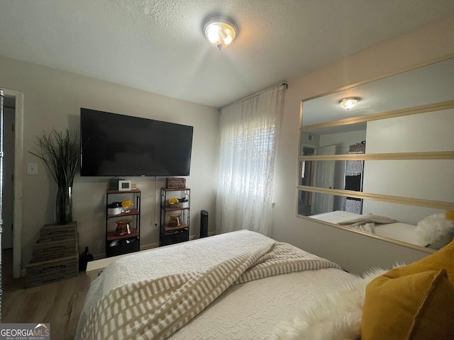 bedroom featuring a textured ceiling and wood-type flooring