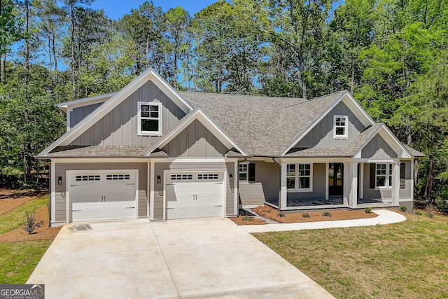 view of front of house with a garage, covered porch, and a front lawn