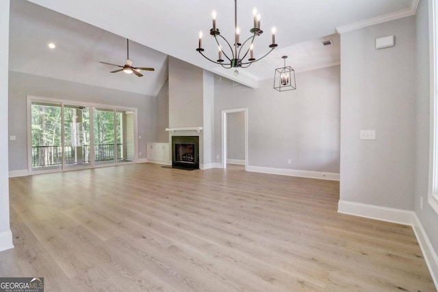 unfurnished living room with ceiling fan with notable chandelier, high vaulted ceiling, and light hardwood / wood-style flooring