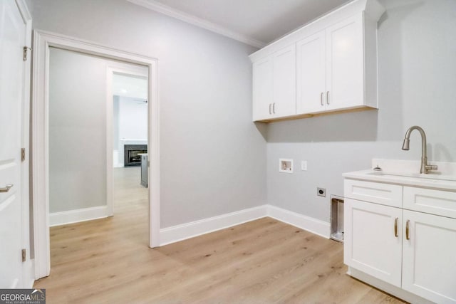 washroom featuring sink, crown molding, cabinets, washer hookup, and hookup for an electric dryer