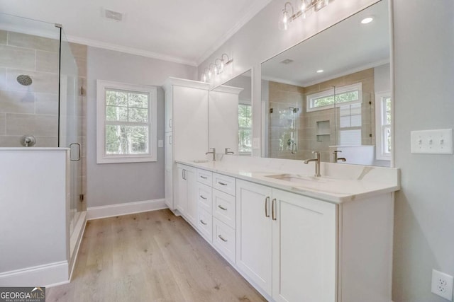 bathroom with crown molding, vanity, hardwood / wood-style flooring, and a shower with door