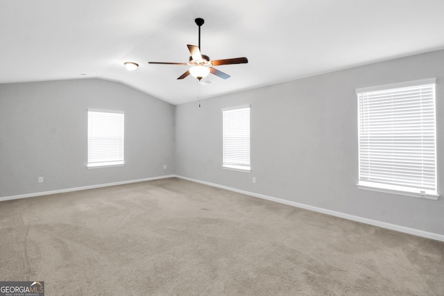 unfurnished room with vaulted ceiling, light colored carpet, and ceiling fan