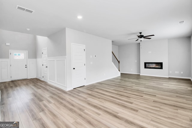 unfurnished living room featuring light hardwood / wood-style flooring and ceiling fan