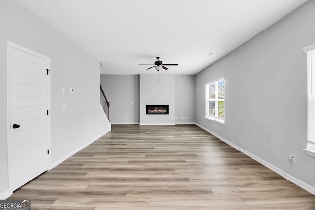 unfurnished living room featuring light hardwood / wood-style floors and ceiling fan