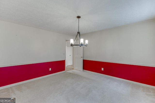 unfurnished dining area with a chandelier, carpet floors, baseboards, a textured ceiling, and ornamental molding