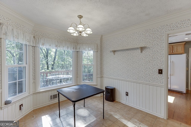 unfurnished dining area featuring light hardwood / wood-style flooring, an inviting chandelier, ornamental molding, and a wealth of natural light