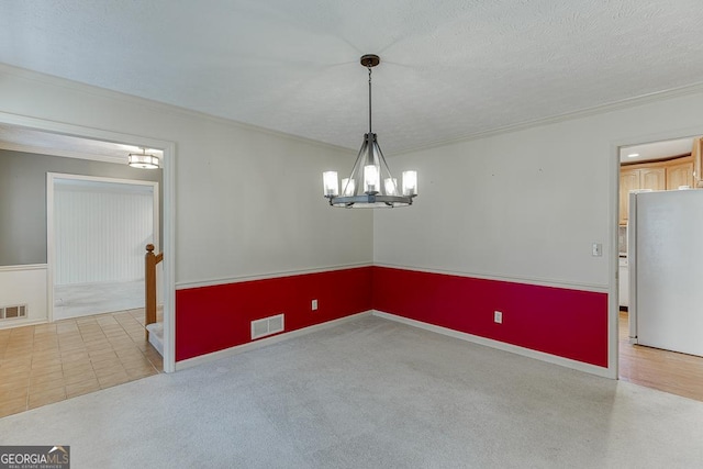 empty room with light colored carpet, visible vents, a chandelier, and ornamental molding