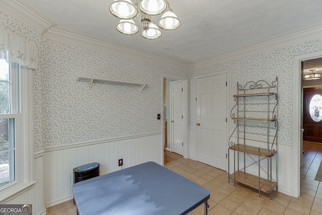 dining area with a notable chandelier, a textured ceiling, ornamental molding, and tile patterned flooring