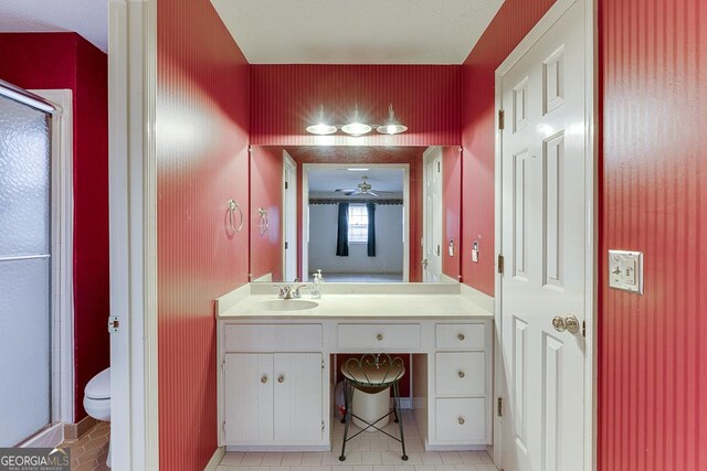 bathroom with vanity, toilet, walk in shower, and a textured ceiling