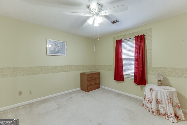 interior space featuring a textured ceiling, light colored carpet, and ceiling fan