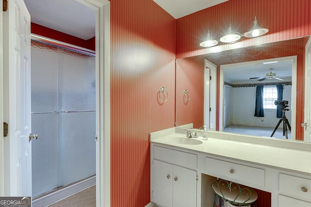 full bathroom featuring vanity, wallpapered walls, a shower stall, and ceiling fan