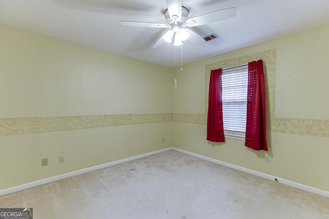 empty room with light carpet, baseboards, a ceiling fan, and visible vents