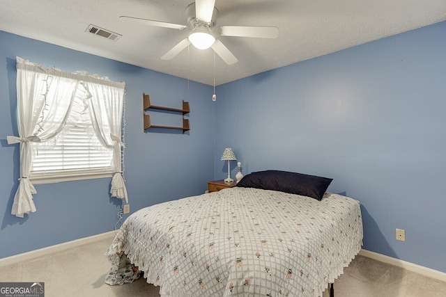 carpeted bedroom with a textured ceiling and ceiling fan