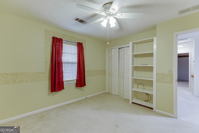 unfurnished bedroom with a closet, light colored carpet, visible vents, and baseboards