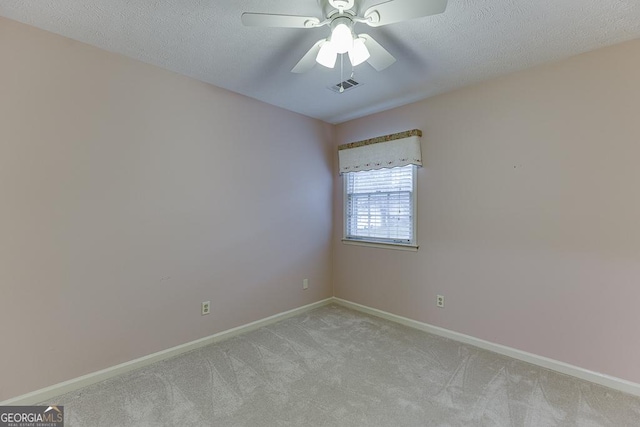 unfurnished room featuring light carpet, baseboards, visible vents, a textured ceiling, and a ceiling fan