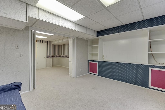 interior space with light carpet, wallpapered walls, and a drop ceiling