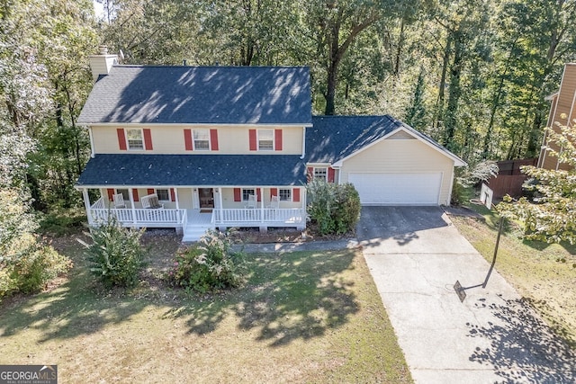 view of front facade with a garage, a front lawn, and a porch