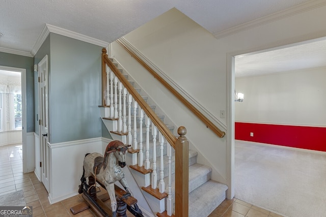 stairway featuring crown molding, a textured ceiling, and tile patterned floors