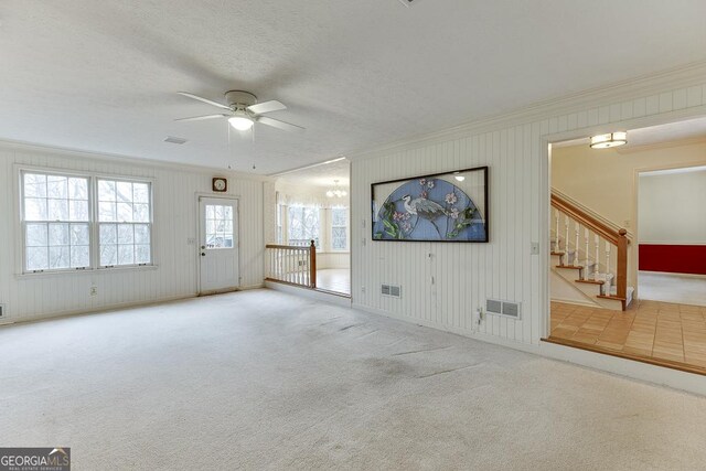 spare room with crown molding, a textured ceiling, a chandelier, and carpet floors