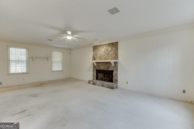 unfurnished living room with a fireplace, light carpet, ceiling fan, and ornamental molding