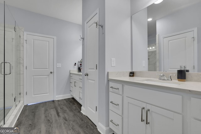 bathroom featuring vanity, a shower with shower door, and wood-type flooring